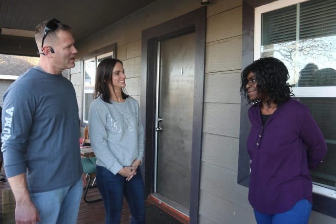 Left to right, Michael and Miranda Vaught speak with tenant Shelia Hawkins on the porch of the home she rents from the couple.